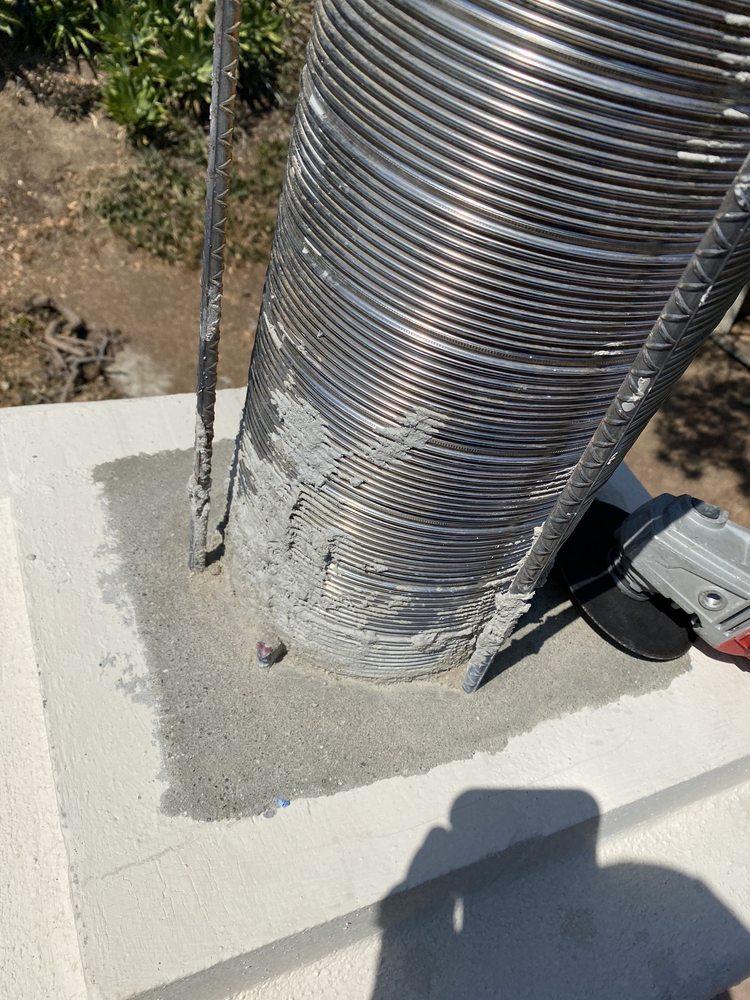 New stainless steel flue liner being set with rebar and mortar at the chimney base