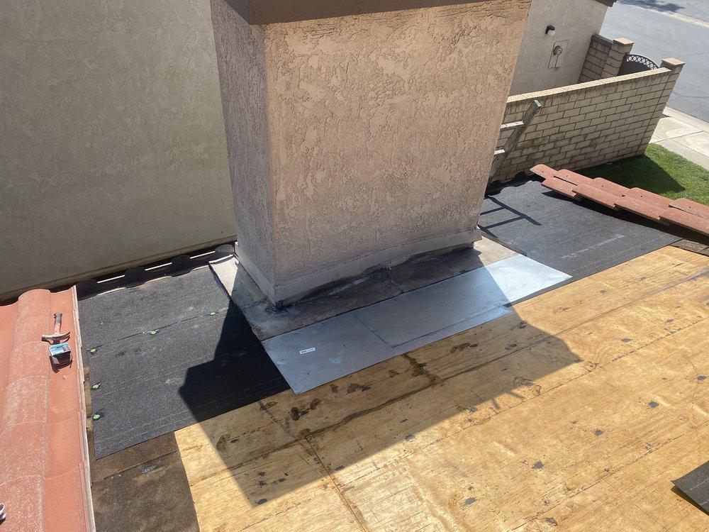 Finished flashing and underlayment at a chimney base