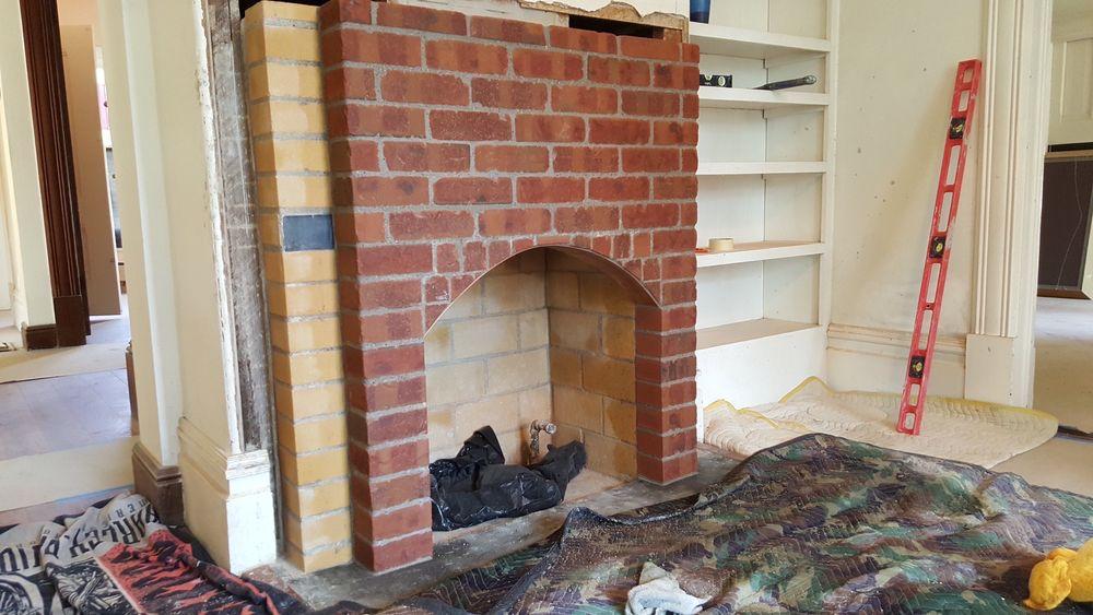 Fully rebuilt two-tone brick fireplace with an arched firebox opening