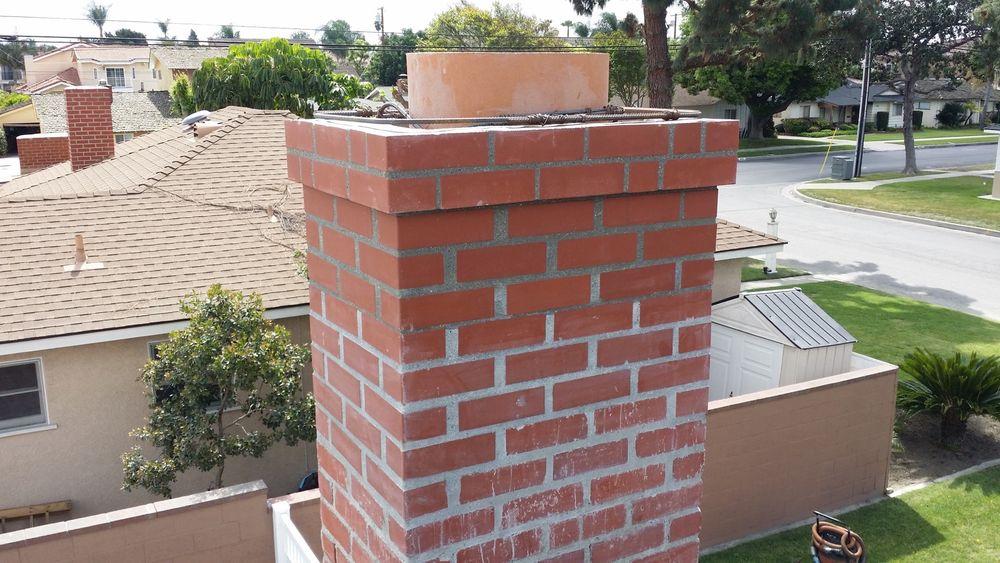 Tall, clean, well-maintained brick chimney against a blue sky
