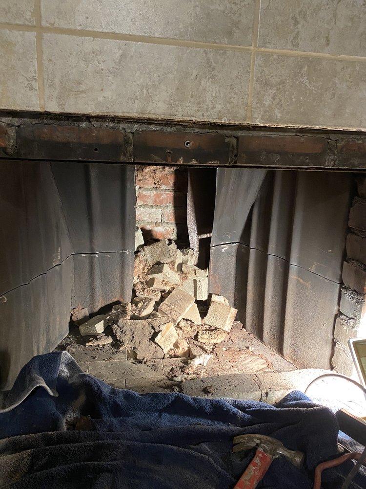 Broken and crumbled firebrick pieces inside a damaged firebox